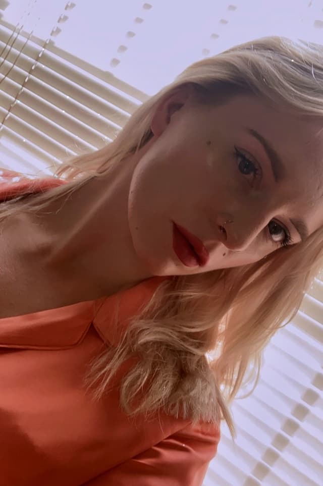 A young woman with blonde hair lies in a hammock, her face partially obscured by the fabric.